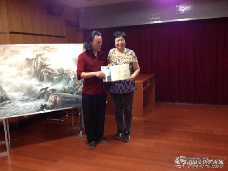 画家闫秀伶在秀山参加第八届彩墨山水研修班领取结业证书与曾刚老师合影