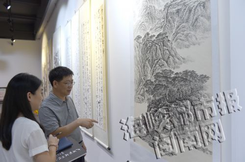 卢美彬在介绍书画作品
